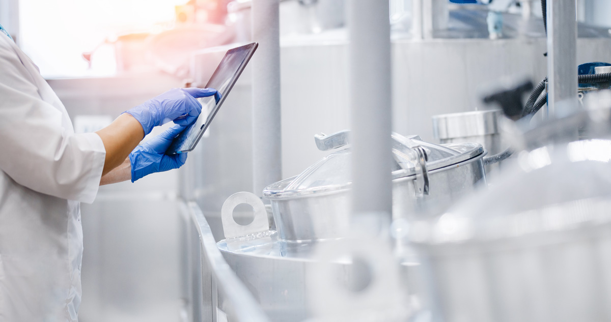 Lab technician using a tablet to monitor the production process