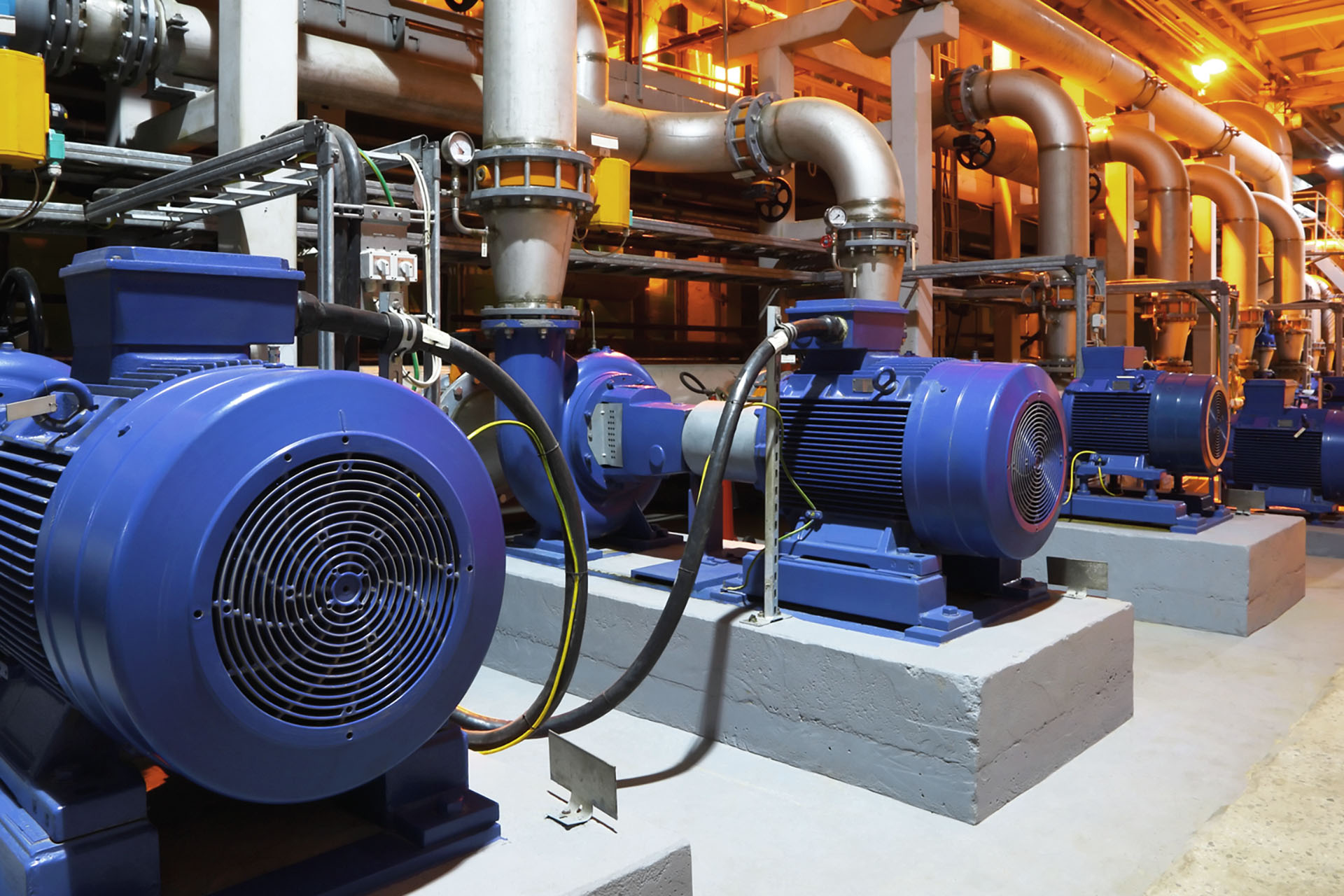 Large blue industrial pumps in a manufacturing facility
