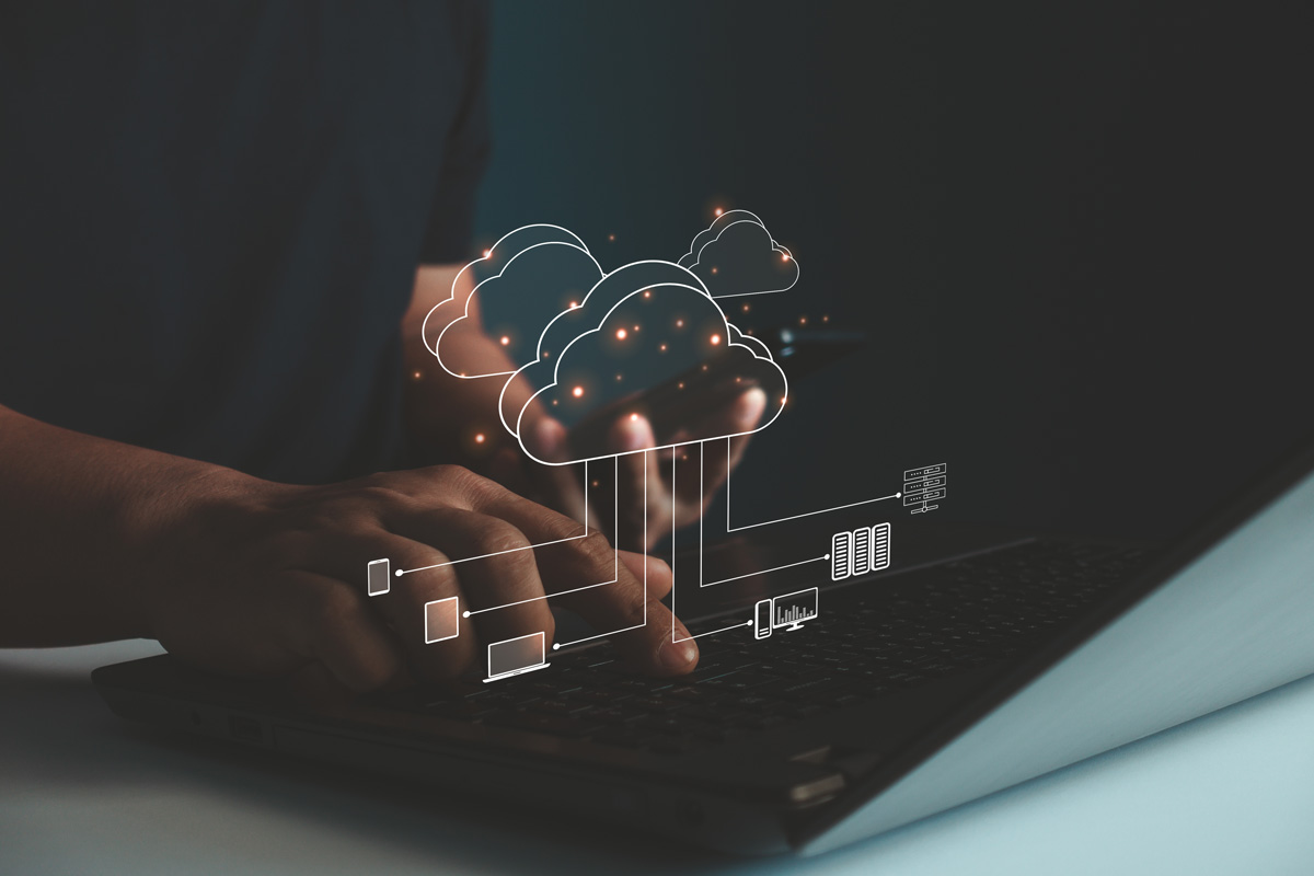 Person typing on a laptop with digital cloud symbols overlay