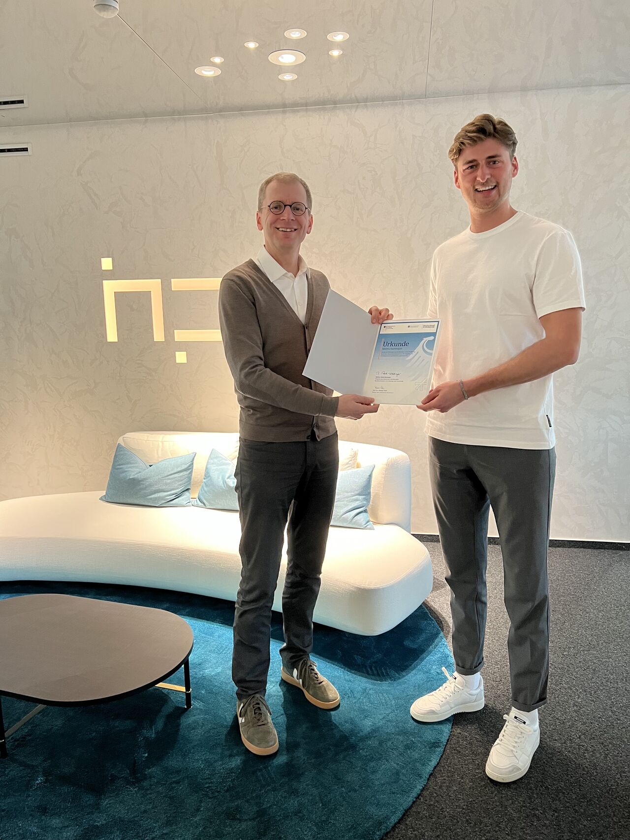 Foto von Ralf Stahl und Mattis Hartmann mit der Urkunde des Deutschland Stipendium